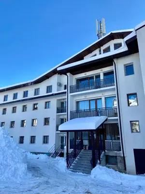a building with snow on the ground in front of it at Apartment in Studenets, Pamporovo in Pamporovo