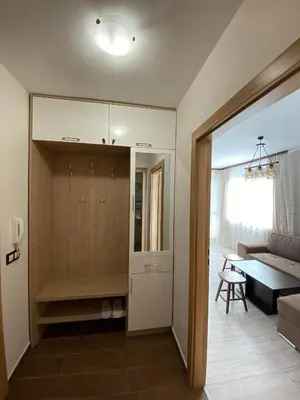 a living room with a bed and a room with a table at Borovets Gardens Ski Apartment in Borovets
