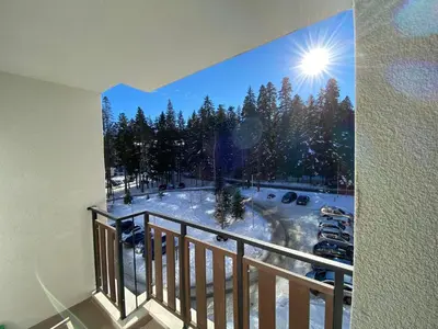 a view of a snow covered parking lot from a balcony at Borovets Gardens Ski Apartment in Borovets