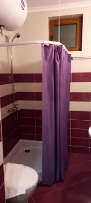 a bathroom with a purple shower curtain and a toilet at Ski Place in Pamporovo