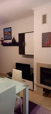 a living room with a table and a fireplace at Ski Place in Pamporovo
