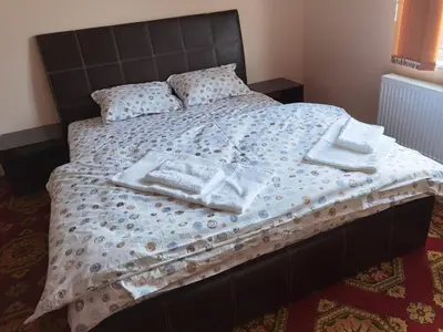 a bed with towels and pillows on top of it at Винарна-Славовица in Kalugerovo