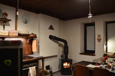 a kitchen with a wood stove in a room at Yakusha - Якуша, къща за гости in Shiroka Lŭka