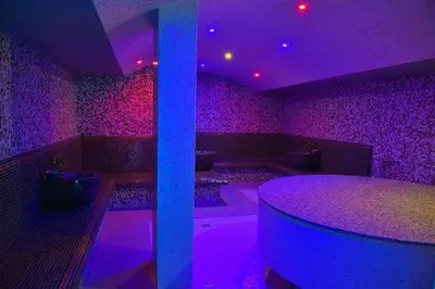 a room with purple lights and a table in it at Belvedere luxury apartment in Bansko