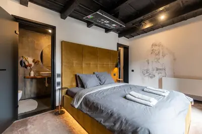a bedroom with a large bed with a wooden headboard at Bashtin Dom - Skabrin House in Bansko
