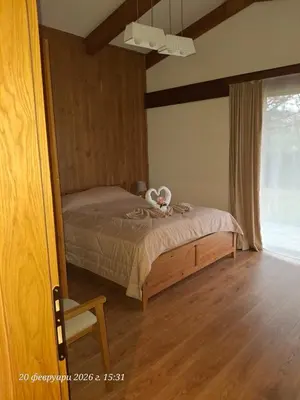 a bedroom with a bed and a chair and a window at Pirin Golf Villa in Bansko