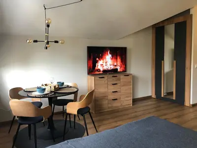 a dining room with a table and a fireplace at Borovets Forest view (A56) in Borovets