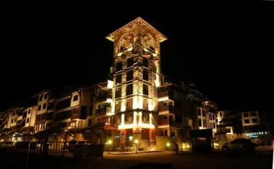a tall building with a clock tower at night at Bansko Royal Towers - Studio 815 in Bansko