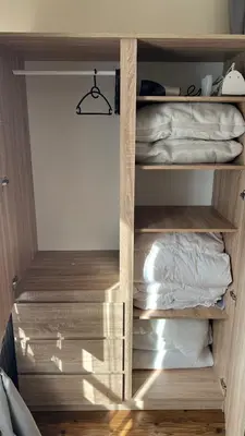 a closet with wooden shelves and a bed at Vesta Boutique Apartment in Bansko