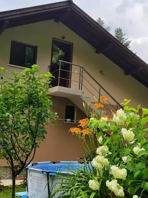 a house with a balcony and some flowers at Еко вила Дивна - Тетевенски балкан in Divchovoto