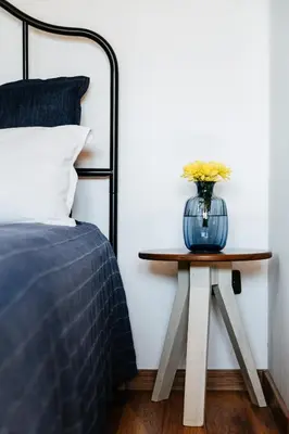 a table with a vase on it next to a bed at Семеен хотел и ресторант Райски залив in Golyama Zhelyazna