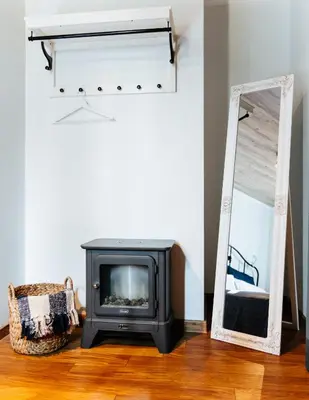 a fireplace and a mirror in a living room at Семеен хотел и ресторант Райски залив in Golyama Zhelyazna