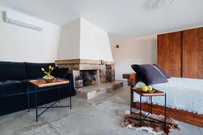 a bedroom with a bed and a fireplace at Семеен хотел и ресторант Райски залив in Golyama Zhelyazna