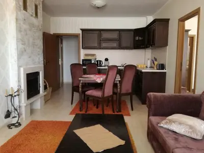 a kitchen and living room with a table and chairs at Гранд Манастира Пампорово, Двустаен апартамент Deluxe in Pamporovo