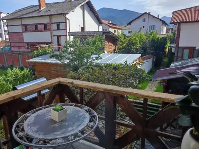 a balcony with a table on a wooden deck at vins studio in Bansko