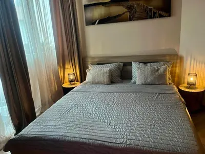 a bedroom with a large bed with two lamps at vins studio in Bansko