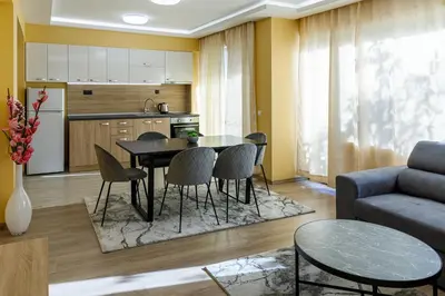 a kitchen and living room with a table and chairs at Баня Аква Ризорт in Banya