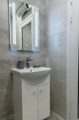 a bathroom with a white sink and a mirror at Баня Аква Ризорт in Banya