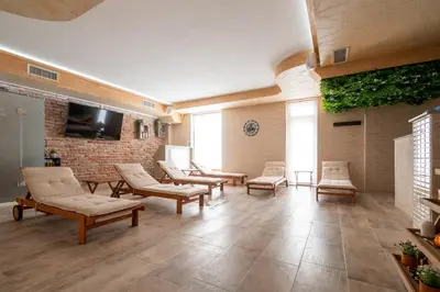 a waiting room with chairs and a flat screen tv at Баня Аква Ризорт in Banya