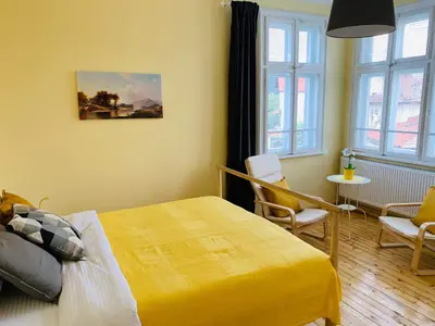 a bedroom with a yellow bed and a table and chairs at TÁNIN HOUSE - Three-bedroom apartment, sauna and gym 10' away from Borovets in Samokov