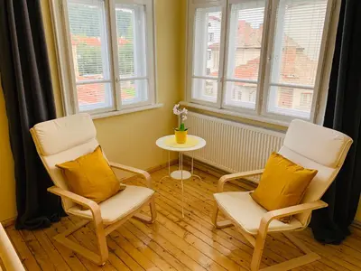 two chairs and a table in a room with windows at TÁNIN HOUSE - Three-bedroom apartment, sauna and gym 10' away from Borovets in Samokov