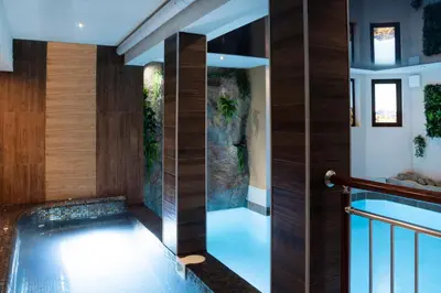 a house with a swimming pool in the middle of a house at Hotel Niken in Pamporovo