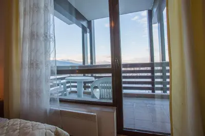 a bedroom with a view of a balcony with a table at Bright Studio in a Spacious Complex in the Valley by Flat Mаnager in Bansko