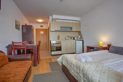 a bedroom with a bed and a kitchen with a table at Bright Studio in a Spacious Complex in the Valley by Flat Mаnager in Bansko