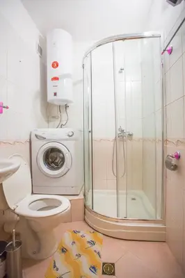 a bathroom with a shower toilet and a washing machine at Cozy One-Bedroom apartment with Nature View by Flat Mаnager in Razlog