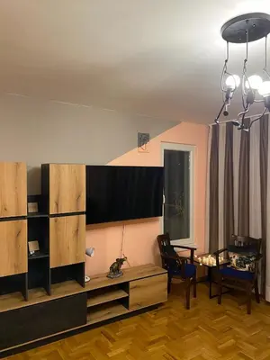 a living room with a tv and a table and chairs at Spacious Apartment next to South Park Просторен Апартамент до Южен Парк Top Location in Sofia