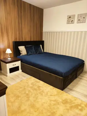 a bedroom with a large bed with a blue bedspread at Bansko Dream Apartment City Center in Bansko