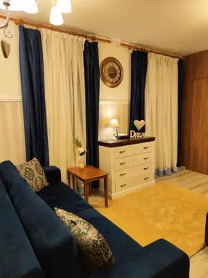 a living room with a blue couch and a dresser at Bansko Dream Apartment City Center in Bansko