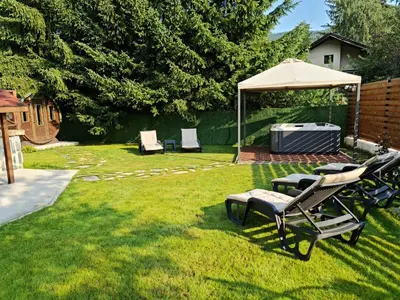 a group of chairs and an umbrella in a yard at Algarte Guest House in Madzhare
