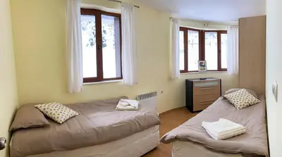 a bedroom with two beds and two windows at Ski Area 202 apt, The Castle 1, Pamporovo in Pamporovo