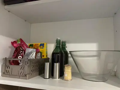 a shelf with two bottles of wine and a basket at Уютен апартамент на 3 мин. от главната и Капана +паркинг in Plovdiv