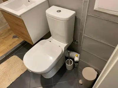 a bathroom with a white toilet and a sink at Уютен апартамент на 3 мин. от главната и Капана +паркинг in Plovdiv