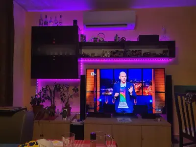 a man standing on a tv in a room with purple lights at Koko's apartments 2 in Bansko