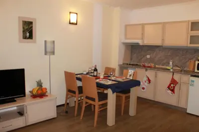 a kitchen with a table and chairs in a room at Apartment Kristin in Apart Hotel Stenata in Pamporovo