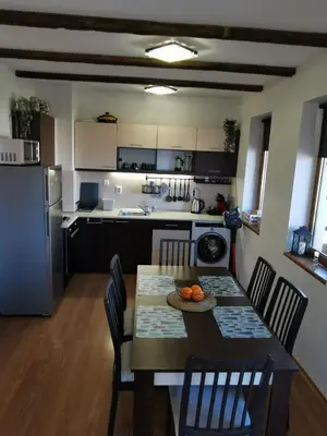 a kitchen with a table and chairs and a kitchen with a refrigerator at Cedar 42 in Bansko