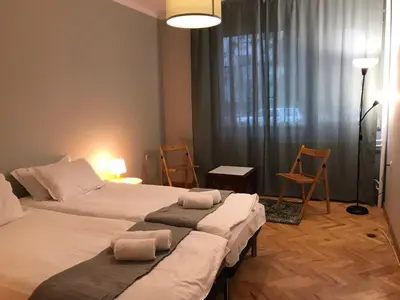two beds in a room with chairs and a window at EU metro station, City Center, lovely 3-bedroom apartment, free parking in Sofia