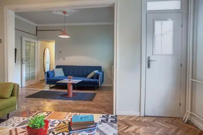 a living room with a blue couch and a table at Sofia center, Shishman street bijou in Sofia