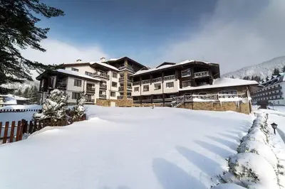 a snow covered yard in front of a lodge at 4 Seasons Apartment 535, Oak Residence in Smolyan