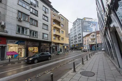 a car driving down a city street with buildings at Elegant 2bdr Apartment with a Balcony in Sofia