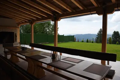 a patio with tables and a view of a green field at Вила Релакс in Pamporovo