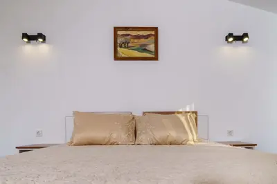 a bedroom with a bed with two lights on the wall at Свети Никола in Razlog