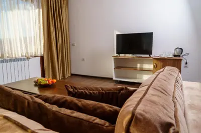 a living room with a couch and a television at Свети Никола in Razlog
