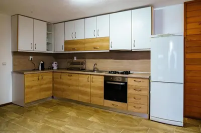 a kitchen with wooden cabinets and a white refrigerator at Свети Никола in Razlog