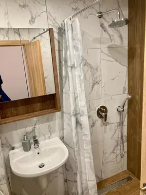 a white bathroom with a sink and a shower at Cactus Apartment in Borovets