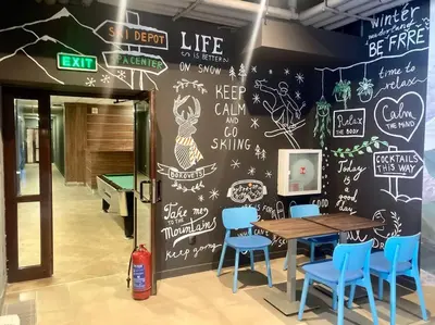 a dining room with a chalkboard wall with a table and chairs at Cactus Apartment in Borovets