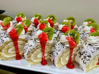 a plate of cakes with whipped cream and red sauce at Kamena Pamporovo in Pamporovo